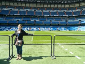 Arielle is standing in front of a sports field. 